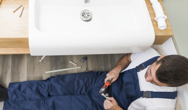 À quelle hauteur installer le drain du lavabo selon la norme de plomberie?